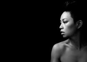 Dramatic black and white portrait capturing a woman's contemplative profile.